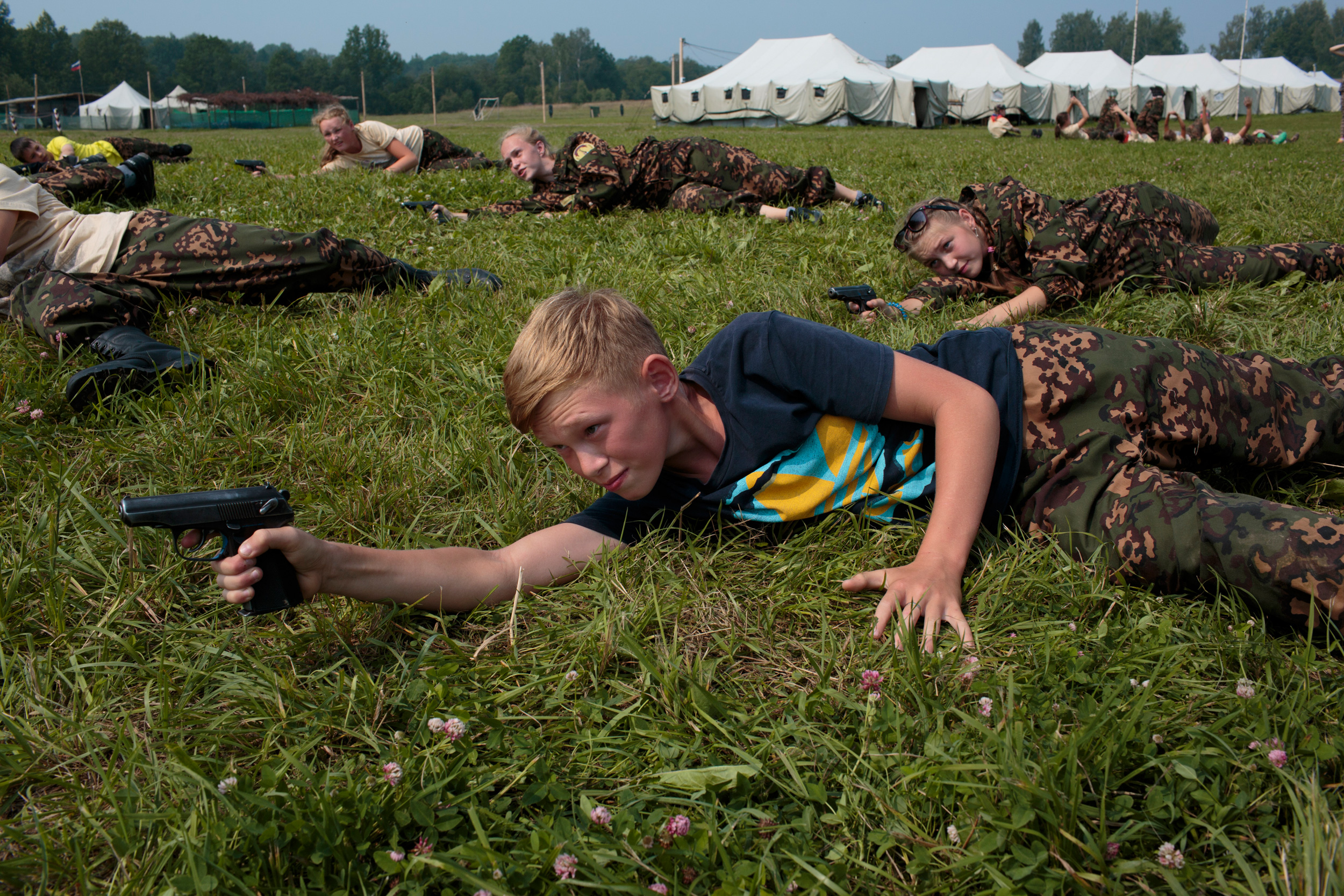 Students train in firearms at the Historical War Camp, in Borodino, Russia. July 24, 2016. Borodino is famous for a battle fought on September 7, 1812—the deadliest day of the Napoleonic Wars. Three hundred fifty adolescents are in attendance, ranging in ages from 11 to 16. They are using air-soft guns for the practice and competition. The camp teaches information about the basic kinds of weapons, bases and firing rules, sniper rifles, and different type of weapons. © Sarah Blesener Students train in firearms at the Historical War Camp, in Borodino, Russia. July 24, 2016. Borodino is famous for a battle fought on September 7, 1812—the deadliest day of the Napoleonic Wars. Three hundred fifty adolescents are in attendance, ranging in ages from 11 to 16. They are using air-soft guns for the practice and competition. The camp teaches information about the basic kinds of weapons, bases and firing rules, sniper rifles, and different type of weapons. © Sarah Blesener